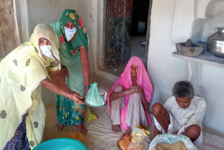 Women members of self-help group distributing ration to poor in Agar Malwa