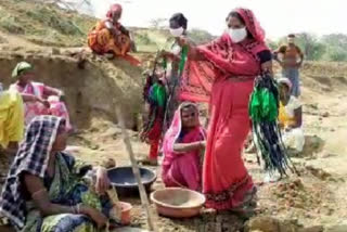 Anganwadi workers distribute masks to MNREGA workers