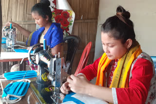 three girls of kokrajhar sewing face masks during corona virus crisis