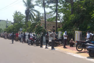 homeless people waiting for lunch at anna canteen in anakapalle