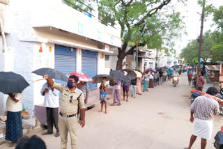 గొడుగు ఉంటేనే మద్యం.. పాటిస్తున్నారు భౌతిక దూరం..