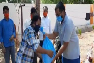 voluntary people distributing essential goods to handicapped persons in guntakal