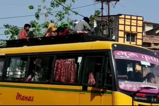 Workers reaching home by reaching roof of bus in chhatarpur