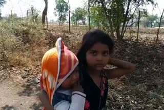 girl walking with her brother in her lap