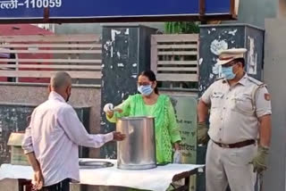 Lady officers are distributing halwa outside the Mohan Garden police station in Delhi