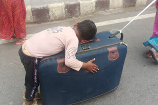 mother carrying her son on suitcase