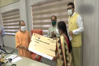 UP CM gives cheques to people involved in MSME sector