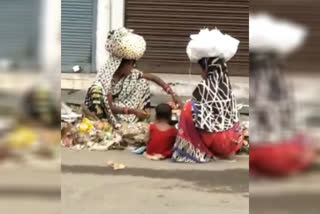 Two women searching for food in the garbage in Damoh