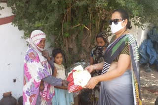 Women distributing clothes and masks to people