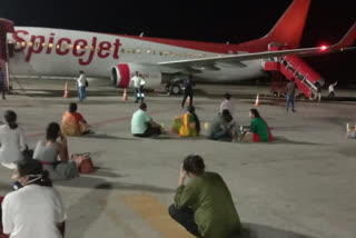 Air passengers sitting near the plane