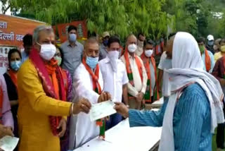 delhi bjp president distributed money and ration to priests