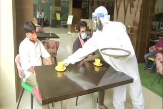 Hotel staff serve its customers wearing PPE kits in Patna