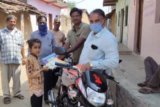 Distributing books to children at home neemuch