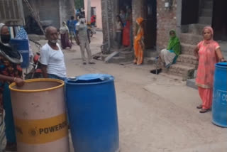 People wait for water tanker to arrive