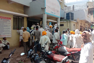 Farmers arriving outside the district cooperative banks for the deducted amount of support price.