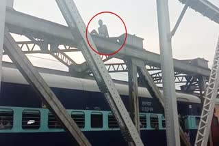 A young man climbed over a railway bridge