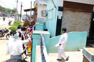 A bank staff in yellareddy, Kamareddy district, is serving customers from outside the gate
