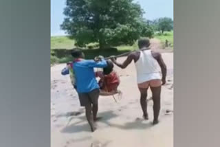 pregnant woman carried on makeshift basket