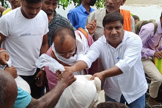 बाढ़ पीड़ितों की मदद करते भाजपा कार्यकर्ता