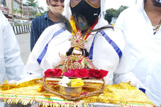 Laddu Gopal rides wearing a mask