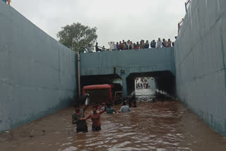 A state transport bus stuck under a waterlogged bridge