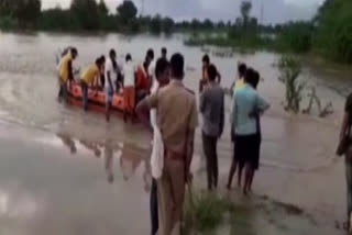 Two dead, two missing after falling in overflowing river