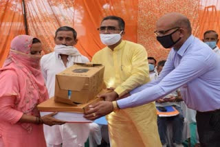 Industry minister Bikram Thakur distributes goods to workers in dehra