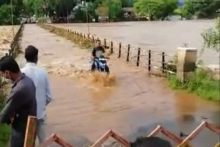 A young man crossing the swollen river risking his life
