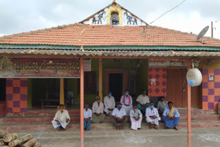 villagers sitting in front of temple