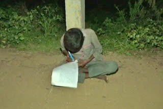 Guy reading under street lights