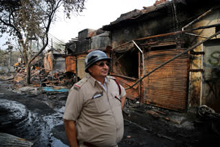 A fire officer standing at the Gokul Puri tyre market which was burnt in Delhi violence