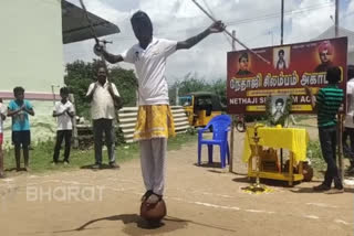 Girl spins double Silambam standing on a pot