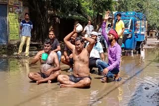 सीवर के गंदे पानी से नहाकर प्रदर्शन करते सपा कार्यकर्ता.