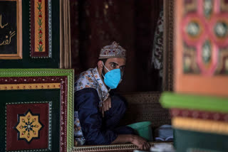 Kashmiri priest wearing a wearing a face mask as a precautionary measure against the coronavirus