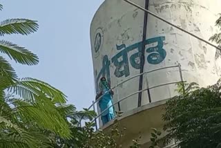 a woman climbs on a water tank