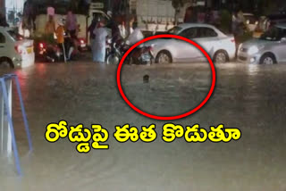 a man swim in a flood water on road in hyderabad