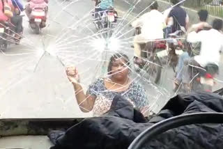 lady hits rtc bus with stones in bapatla