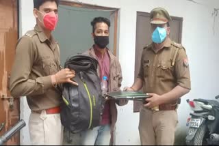 युवक बैग लौटाती पुलिस.