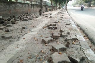 people facing problem due to piece of stones spread on pavement at dwarka sector 11 metro station