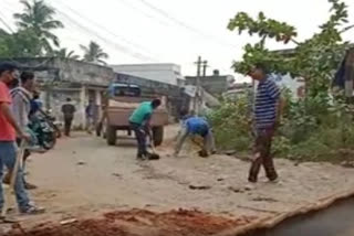 Police  fill up  potholes on the road in Ichapuram