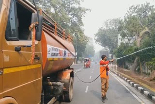 PWD tanker Spraying water on tree pavement in Delhi due to increasing pollution