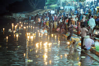 devotees throwing lights into the river