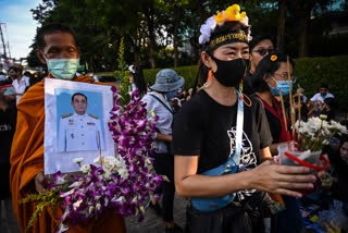 A Buddhist monk carries a portrait of Thailand's Prime Minister Prayuth Chan-O-Cha during a mock funeral outside the headquarters of the Siam Commercial Bank on November 25, 2020 in Bangkok, Thailand.
