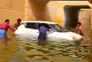 Car floating in rain water on railway tunnel bridge