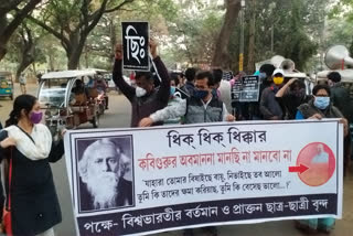 Picture of Rabindranath below Amit Shah  procession in Santiniketan to protest  Amit Shah in Bengal  Gurudev  Santiniketan protests  രബീന്ദ്രനാഥ ടാഗോറിന് മുകളിൽ അമിത് ഷായുടെ ചിത്രം; പ്രതിഷേധമുയർത്തി അധ്യാപകർ  രബീന്ദ്രനാഥ ടാഗോറിന് മുകളിൽ അമിത് ഷായുടെ ചിത്രം  പ്രതിഷേധമുയർത്തി അധ്യാപകർ  അമിത് ഷായുടെ പശ്ചിമ ബംഗാൾ സന്ദർശനം  കേന്ദ്ര ആഭ്യന്തരമന്ത്രി അമിത് ഷാ  രബീന്ദ്രനാഥ ടാഗോർ  തൃണമൂൽ പിന്തുണയുള്ള അധ്യാപകർ  picture of rabindranath below amit shah, teachers' protest