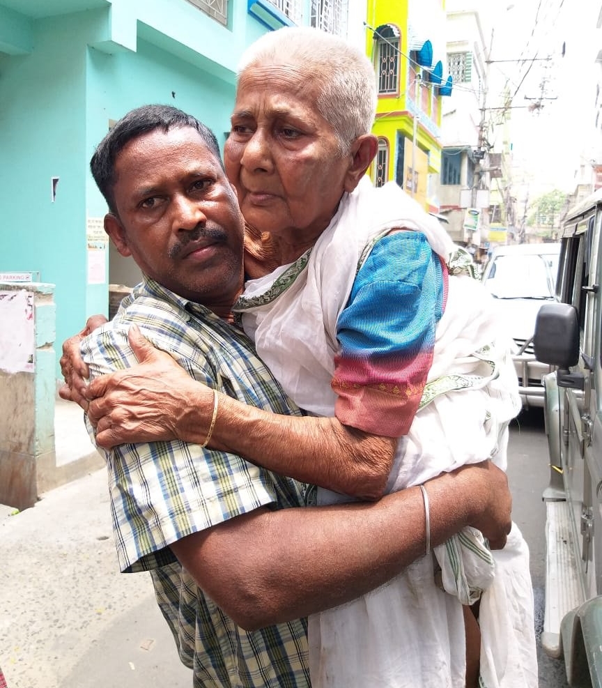 Son carries his 80-year-old mother to polling station