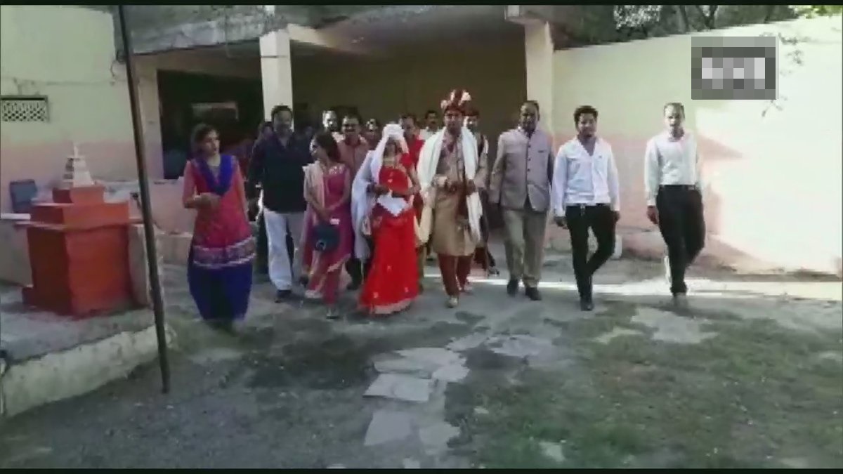 Bride and groom along with their family cast their votes at a polling station in Indore.