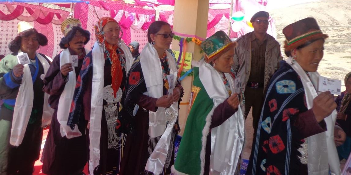 People stand in a queue to cast their vote