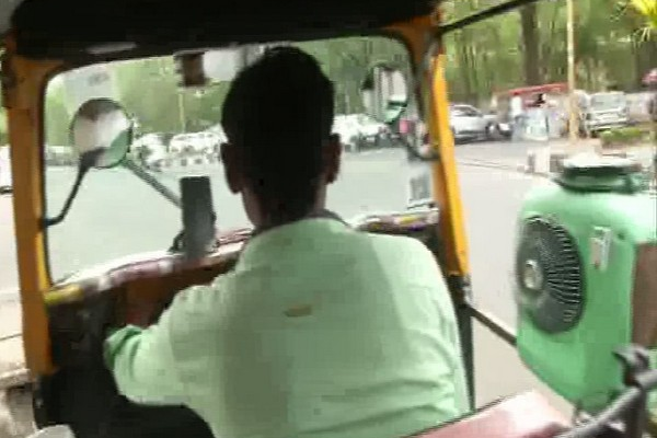 An Auto driver driving his auto with self-made cooler