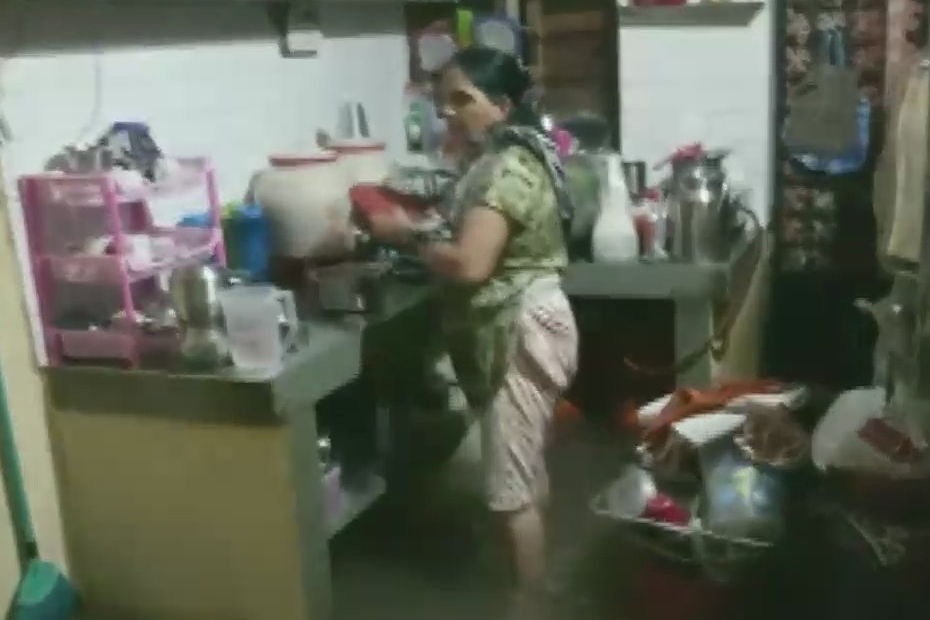 Mother cooking food even Kitchen is flooded with water